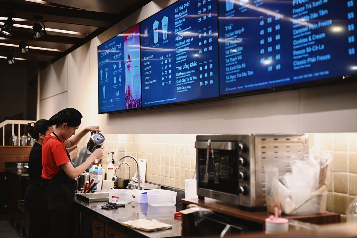 Digital menu board displaying content on screens in a modern coffee shop