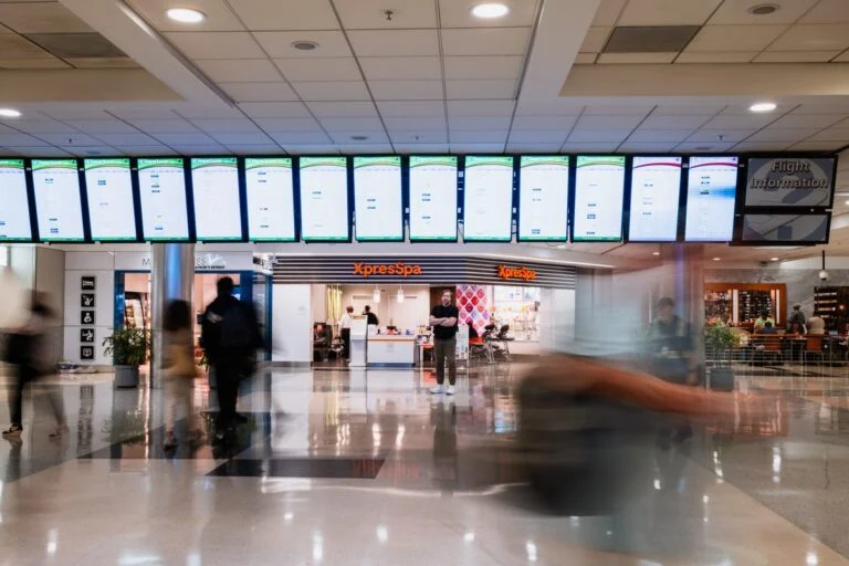 Digital signage screens displaying live information in a busy public space