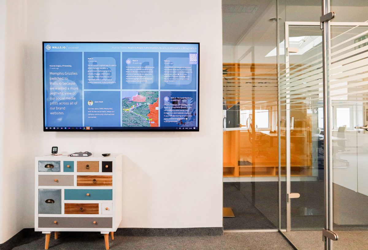 Corporate digital signage screen showing a data-driven presentation in an office