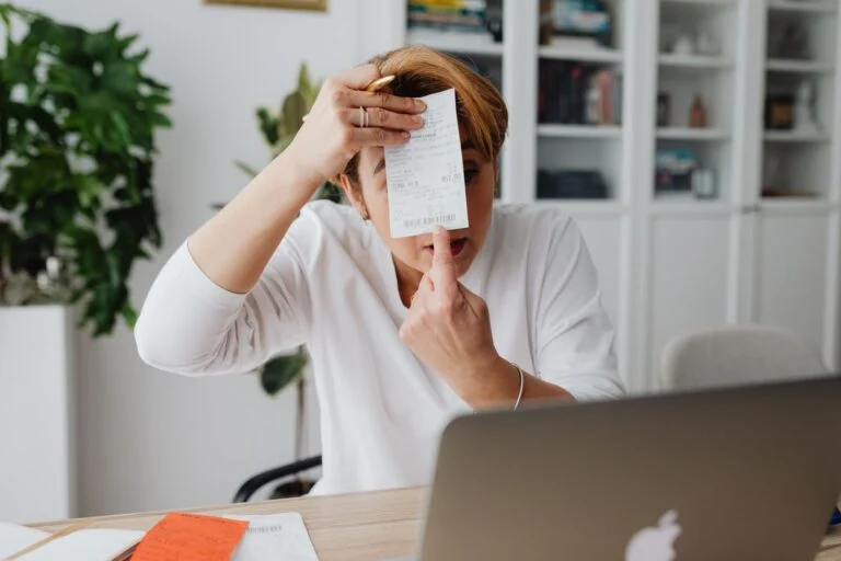 Small business owner reviewing invoicing and reporting on a laptop