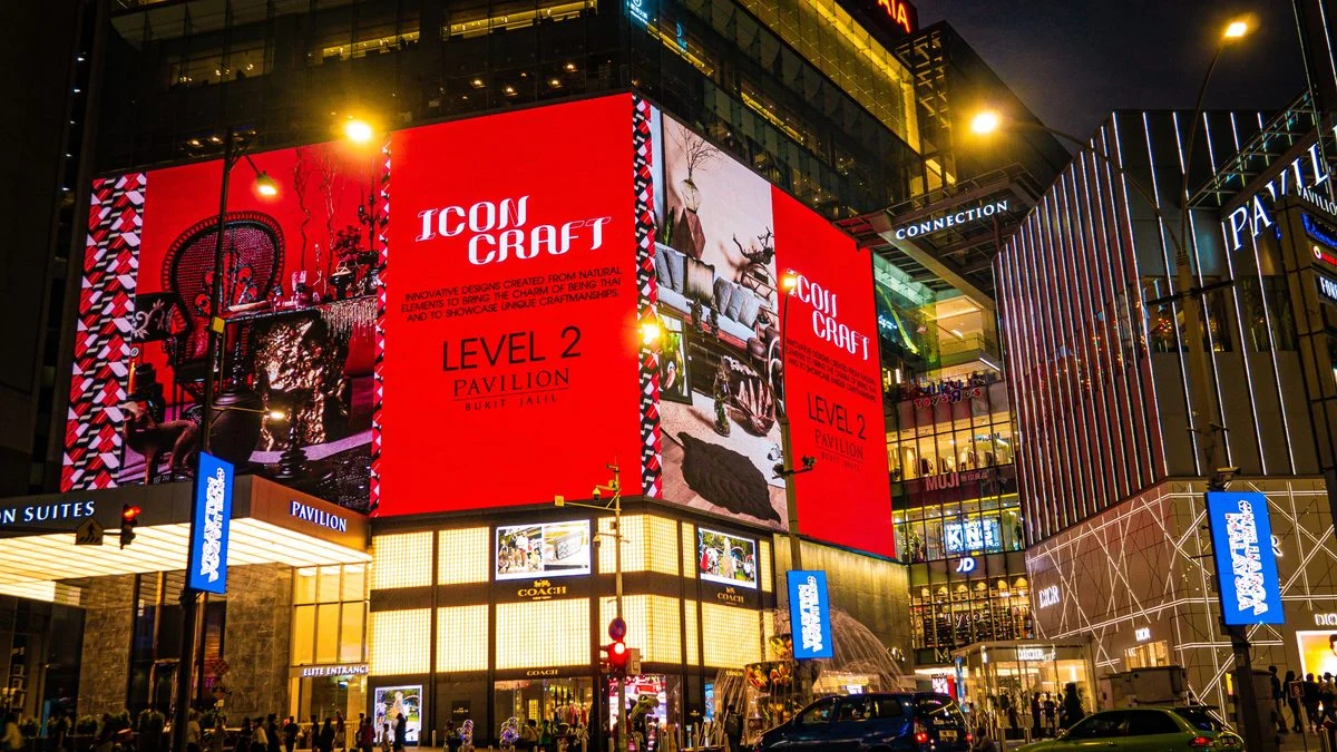 Bright digital advertising displays on a retail building at night